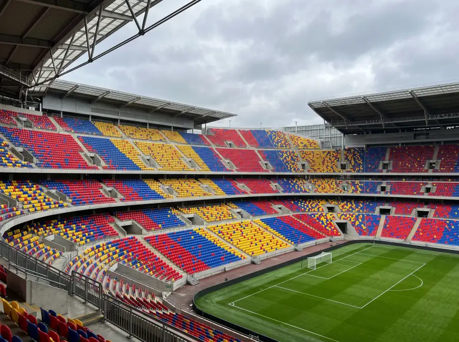Gradas de un estadio de futbol llenas de asientos de colores vivos sin espectadores