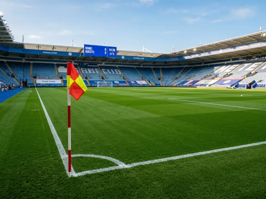 Campo de futbol profesional con las lineas de juego perfectamente marcadas visto desde la banda